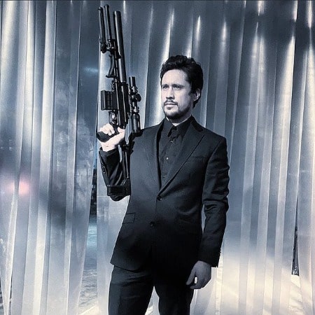 Picture of Peter Gadiot holding a fake gun on the shooting of his series.